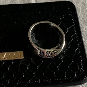 Maison Margiela ring  - Maison Margiela ring med deras ikoniska numrering ingraverad runt ringen. Siffran 11 är markerad vilket står för deras smyckeskollektion. Ca 1,8 cm i diameter