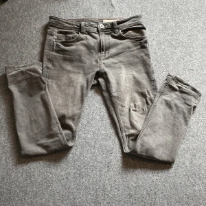 Jeans slim fit - Säljer ett par grå slim fit jeans från Livergy med klassisk femficksdesign och knappgylf. Jeansen har en diskret tvättad look och är tillverkade i ett mjukt denimtyg. Perfekta för dig som gillar en smalare passform.