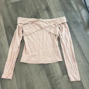 Ljusrosa offshoulder topp från BikBok - Säljer en ljusrosa offshoulder topp från BikBok. Toppen har långa ärmar och en snygg omlott-detalj vid halsen. Perfekt för dig som gillar en feminin och trendig stil. Pris kan diskuteras och skriv för fler bilder 💓