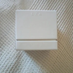 LXA Scent 01 Eau de Parfum - Modern parfym från LXA i stilren vit förpackning. Doften har toppnoter av bergamott, citron, apelsin och svarta vinbär, hjärtnoter av apelsinblomma, cyklamen och ylang-ylang samt basnoter av vanilj, mysk, cederträ och vetiver.