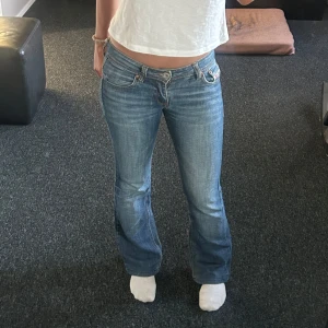 Diesel Bebel bootcut jeans blå - Säljer ett par snygga Diesel Bebel jeans i klassisk blå tvätt med bootcut passform. Låg midja och coola broderade detaljer på bakfickorna. Jeansen är i äkta denim och har en riktigt skön vibe, perfekta till sneakers eller boots.