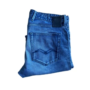 Replay jeans  - Snygga blå jeans från Replay med klassisk femficksdesign och raka ben. Jeansen har coola slitningar och tydliga sömmar på bakfickorna. Materialet är mjukt jeans i bomull, perfekt för en avslappnad stil. Längd 107cm midja 44cm. Se defekt på sista bilden !  Jag skickar ej bild när jag bär plaggen och jag vet ej vilken längd och vikt de passar då jag inte prövar kläderna jag säljer 😃