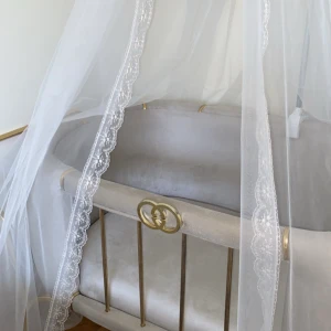 Elegant spjälsäng - Hej! Säljer min sons eleganta spjälsäng med gulddetaljer och vit spetsgardin. Han har bara sovit i den 1 gång, sängen är inköpt för 3 månader sen. Säljer den för 3000kr själv köpt den för 5000kr!