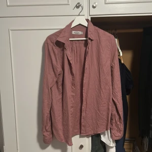 Rosa linneskjorta från Dressmann S - Säljer en stilren rosa skjorta från Dressmann i premium linne. Skjortan har klassisk krage, långa ärmar och knäppning framtill. Perfekt för dig som gillar en avslappnad men snygg look. Passar lika bra till jeans som till chinos.