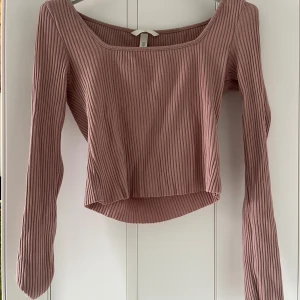 Rosa ribbad långärmad topp H&M - Supersnygg ljusrosa ribbad topp från H&M med lång ärm och fyrkantig ringning. Croppad modell som sitter snyggt till både jeans och kjol. Mjuk och stretchig i bomullsmix.