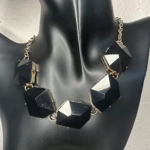 Chunky svart statement-halsband - Vintagehalsband i klassisk 80-talsstil med stora facetterade delar i svart akryl och justerbar kedja i guldfärgad metall. Ca 58 cm långt och upp till 2,8 cm brett. Perfekt som kraftfull accessoar till fest eller en minimalistisk outfit. Ingen prutning – men jag erbjuder bundlerrabatt. Jag rensar smyckesskrin och garderob – spana gärna in mina andra annonser!  ⸻ 