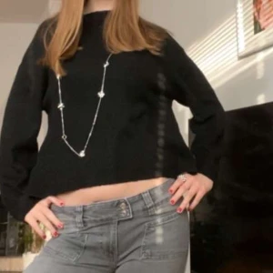 Svart croppad stickad tröja 157 - Svart croppad stickad tröja från 157 med rund halsringning och lång ärm. Tröjan är lite nopprig