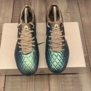 Nike blågröna fotbollsskor med snörning - Snygga fotbollsskor från Nike i en skimrande blågrön färg med quiltad struktur och vita detaljer. Skorna har vit snörning och plös, samt en vit Nike-logga på sidan. Perfekta för dig som vill sticka ut på planen. Det är även konstgräs skor.