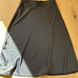 Blå midi kjol - Midikjol i satinaktigt tyg från H&M. A-linjeformad. 