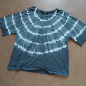 Batikmönstrad Tshirt - En gråblå tshirt med fint vitt batikmönster. 100% bomull, skön och basic med en liten ficka på ena bröstet. Storlek S från Gina Tricot, passar upp till M. I princip i nyskick! 