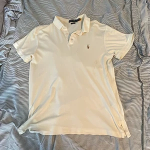 Pikétröja från Ralph Lauren - Vit/Beige pikétröja från Ralph lauren. Storlek M men passar mer som S. Skönt och mjukt material. Mycket bra skick förutom en halvt-synlig fläck på framsidan. Endast använd ca 5 gånger. 