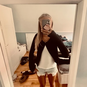 Svart kofta från Gina Tricot - Svart kortare kofta från Gina Tricot med bara en knapp på framsidan. Säljer den för att den är lite kort på mig så skulle säga att den är mer xs, har haft ett hål i ärmen men är sytt (3 bilden). Skriv för frågor eller fler bilden, tryck gärna köp nu😌