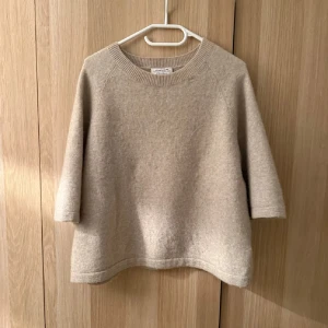 Beige stickad tröja & Other Stories - Beige stickad tröja från & Other Stories med rund halsringning och trekvartsärm. Tröjan är i en mjuk alpackablandning och har en loose passform som ger en chill och avslappnad vibe. Perfekt att styla med jeans eller kjol för en enkel men snygg look.