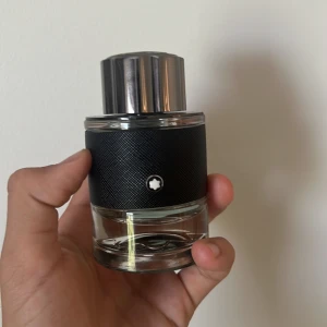 Montblanc Explorer Eau de Parfum - Montblanc Explorer parfym i en stilren glasflaska med svart texturerad hylsa och silverfärgat lock. Flaskan har Montblancs ikoniska vita stjärnlogo framtill. Doften är maskulin och modern, perfekt för dig som gillar exklusiva parfymer.  30 ml kvar av 60