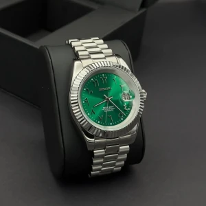 Seiko datejust green Arabic  - Snygg Seiko klocka med grön urtavla och arabiska siffror. Boetten och länken är i silverfärgat rostfritt stål. Klockan har automatisk rörelse och datumfönster med förstoringsglas. Perfekt accessoar för dig som gillar stilren design med en färgklick.