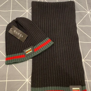 Mössa & Halsduk  - Helt nytt sett av mössa och halsduk i färgen svart, röd och grön med metall-logotyp. 