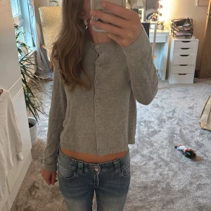 Grå kofta med knappar från Lager 157 - Snygg grå kofta från Lager 157 med rund halsringning och knappar hela vägen framtill. Ursprungliga storleken är M men har förmodligen krympt i tvätten då den passar mig perfekt som har storlek XS-S