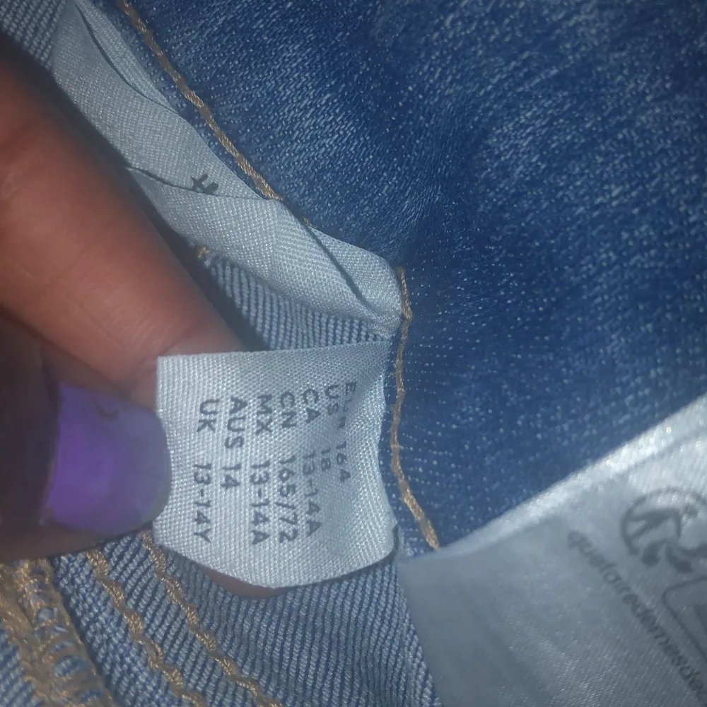 Säljer ett par klassiska blå jeans med bootcut passform. Byxorna har snygga fickor med lock och knapp bak, samt lågmidjad midja. Perfekta för dig som gillar en tidlös jeansstil med lite utsvängda ben.. Farkut & Housut.