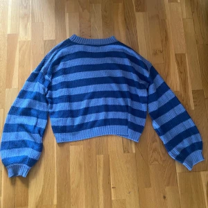 Blå och ljusblå randig croppad stickad tröja - Säljer en croppad stickad tröja i blå och ljusblå ränder från SHEIN. Tröjan har långa ärmar och ribbade muddar vid ärmslut och hals. Använt några gånger men inga tecken på det. Storlek S💘