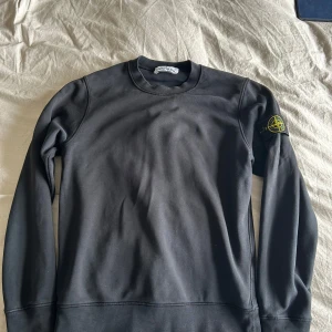 Stone Island Sweater - Stone Island i klassisk svart, 100 % äkta. För att bevisa äktheten finns en QR-kod på en av bilderna. QR-koden är dock täckt i annonsen för att förhindra att den blir ogiltig om flera skannar den. Skicka ett meddelande om du är intresserad, så skickar jag koden direkt till dig!  Detaljer:  • Marke: Stone Island • Färg: svart • Storlek:S  • Skick: 10/10 • Material: Bekvamt och slitstarkt tyg Tröjans ikoniska Stone Island-kompasslogotyp på vänster ärm gör den igenkännbar och ger en exklusiv touch.