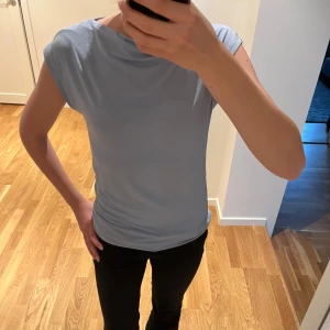 Ljusblå enkel topp - Säljer denna ljusblåa topp från lager 157 i storlek xs. Materialet är väldigt mjukt och den är knappt använd så mycket bra skick.