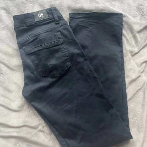 Svarta/mörkblå low waist jeans från LTB - Säljer ett par svarta/ mörkblå jeans från LTB. Byxorna har en rak passform och är perfekta för en stilren look. Snygga detaljer vid fickorna. Hör av er om ni vill se fler bilder!💕