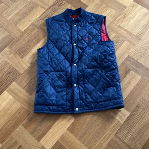 Polo Ralph Lauren Väst - Hej!Jag säljer en väst från Ralph lauren. Köpte västen för cirka 2000kr, 2024. Har användit västen ungefär 1-2 gånger. Säljer den pga av ingen användning. Västen passar en om man är ungefär 165cm lång
