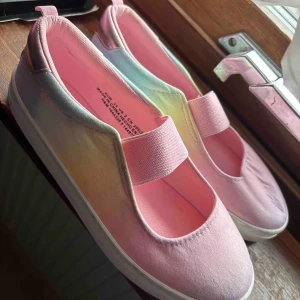 Pastellfärgade ballerinaskor från H&M - Säljer ett par ballerinaskor från H&M i pastellfärger med rosa insida och ovandel. Skorna har en bred resår över foten för extra komfort och en vit platt sula. Perfekta för dig som gillar färgglada och bekväma skor. Nya och oanvända.