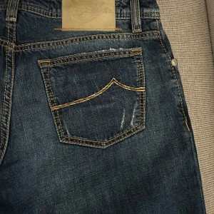 Jacob Cohën Jeans - Säljer ett par mörkblå jeans från Jacob Cohën. Jeansen har rak passform och är tillverkade i ett slitstarkt denimtyg. Perfekta för dig som gillar högkvalitativa jeans i god passform. Nypris ligger på 4000kr. Kontakta vid frågor!!