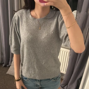 Grå stickad tröja med kort ärm - Säljer en enkel och stilren grå stickad tröja med korta ärmar och rund halsringning. storlek m från only