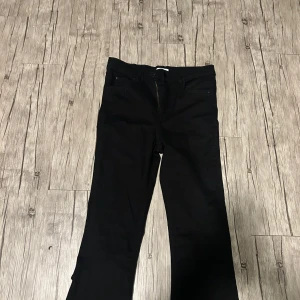 Svarta bootcut jeans från Perfect Jeans- Gina tricot  - Säljer ett par svarta bootcut jeans från Perfect Jeans i storlek M. Byxorna har klassisk femficksdesign, knapp och dragkedja framtill samt en snygg bootcut passform. Perfekta till många olika outfits.