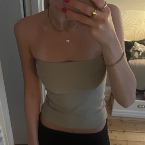 Beige tubtopp - Snygg beige tubtopp som sitter tight och är perfekt för sommaren. Endast andvänd 1 gång så den är i toppen skick🙏skriv vid funderingar💕