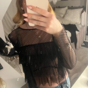 Svart volang blus - Så fin blus från Zara! Bandet till knappen där bak har gått av (se bild 3) men funkar utmärkt att dra en säkerhetsnål runt istället! Superfin att ha ett linne under även! Knappt använd
