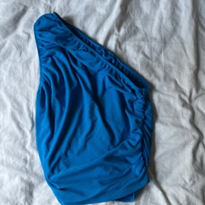 Mörkblå topp - Säljer denna mörkblåa topp som går över ena axeln, mycket fint skick 