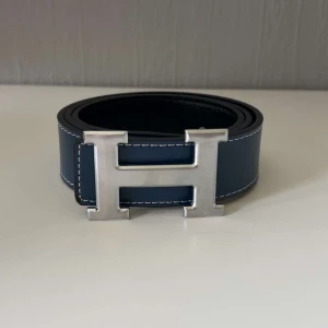 Bälte med h spänne  - Blått bälte med h spänne perfekt till dig som vill lyfta din outfit med ett stilrent bälte 