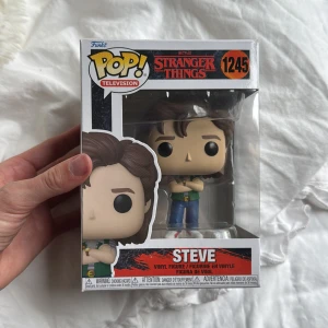 Stranger Things: Steve (Funko Pop! #1245) - Cool Funko Pop! vinylfigur av Steve från Netflix-serien Stranger Things. Perfekt för fans och samlare som vill ha en ikonisk karaktär från den populära serien i sin samling. Snygg design och originalförpackning – ett måste för alla Stranger Things-entusiaster! Pris kan diskuteras! 