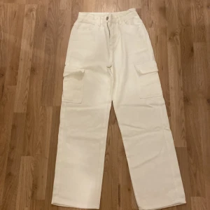 Vita cargopants från SHEIN XS - Snygga vita cargopants från SHEIN i storlek XS Petite. Byxorna har raka ben, hög midja och stora fickor på sidorna. Tillverkade i ett mjukt bomullstyg som känns skönt mot huden. Perfekta för en chill och trendig look dem är nya.
