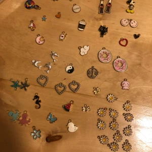Mixade emalj berlocker till smycken - Stort set med mixade berlocker i olika former och färger, perfekta för att göra egna armband, halsband eller örhängen. Innehåller motiv som hjärtan, blommor, stjärnor, djur, donuts och smileys. Materialen är mestadels metall och emalj i guld, silver och färgglada nyanser. Det är 59 st berlocker. Man kan även köpa i mindre pack och välja vilka berlocker man vill köpa, bara säg till då. Säg även till om du behöver mer information!💞