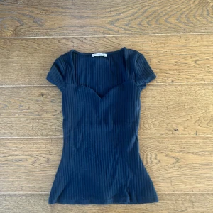 Svart ribbad topp från Anna Field - Snygg svart ribbad topp från Anna Field med korta ärmar och v-ringad sweetheart-urringning. 