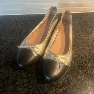 Ballerinaskor  - Säljer dessa supersnygga och ascoola ballerinaskor i en festlig guldig färg. De är endast använda ett fåtal gånger och därför i superbra skick. De är sanna till storlek, passar bra på mig som har 38.5/39 i vanliga fall. De är perfekta både till mer vardagliga och festliga tillfällen🔥🔥🔥Hör gärna av er vid frågor och tveka inte att lägga prisförslag