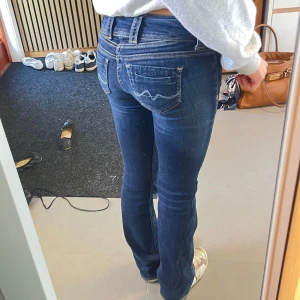 Bootcut Pepe Jeans - Pepe Jeans med skitsnygga detaljer och  boot cut modell, lågmidjade och tvär snygg färg på tvätten och sömmarna!! Älskar dessa!!! Stretchiga och storlek w24 L32. Är öppen för prisförslag!! ⭐️⭐️Fler snygga jeans finns i min profil!!!
