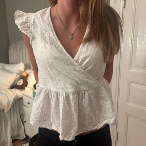 Vit omlottblus med broderade detaljer - Supersötblus som knyts i nacken. Jättefint skick🌺🌺🌺💓💓💓
