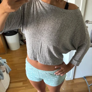 Grå off-shoulder topp - ONLY XS - Superchill ribbad topp från ONLY i grått. Croppad modell med trekvartsärmar, loose fit och snygg offshoulder-look. Perfekt för en laid-back vibe men ändå stilren. Skön kvalitet som funkar året runt – från vår till vinter!  📏 Storlek XS (passar även S) 🧼 Väldigt fint skick 📬 Snabb frakt 