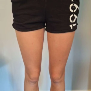 Mjukisshorts - Svarta mjukis shorts med text. (De är lågmidjade men syns inte på bilden). Storlek 134/140 men passar xxs/xs, pris går att diskuteras och det är rabatt på bundles