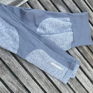 Grå leggings från Doyoueven - Snygga gråmelerade leggings från Doyoueven med ribbade detaljer och hög midja. De är tillverkade i en stretchig mix av polyester och bomull, perfekta för träning eller chill. Logga på benet och seamless design för extra komfort.