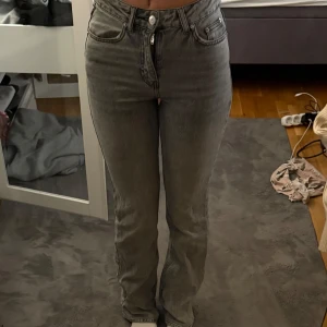 Grå high waist jeans från gperfect - Säljer ett par grå jeans från gina perfect jeans i storlek 32. Modellen är mid rise och full length flare och klassisk femficksdesign. Jeansen har en snygg tvättad grå färg och är tillverkade i jeansmaterial med dragkedja och knapp framtill. (slutsålda)!!