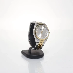 INEX klocka i silver och guld - Stilren klocka från INEX med rund urtavla i silver och gulddetaljer. Länken är tvåfärgad i silver och guld, vilket ger en snygg kontrast. Klockan har tydliga indexmarkeringar och datumfönster. Perfekt accessoar för dig som gillar klassisk design.                                            Behöver ett nytt batteri.