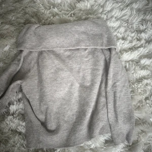 Ljusgrå offshoulder stickad tröja H&M - Supermjuk ljusgrå stickad tröja från H&M med bred offshoulder-krage. Perfekt för dig som gillar en chill men ändå snygg vibe. Tröjan har lång ärm och är i ett skönt material som känns både mysigt och stilrent. Tar frakt!