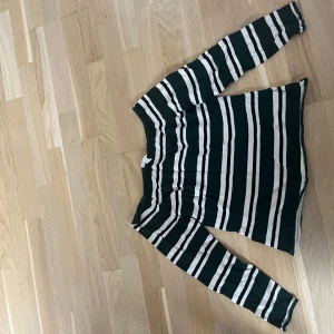 Randig långärmad tröja från H&M - Säljer en chill långärmad tröja från H&M i storlek L. Tröjan har breda horisontella ränder i mörkgrönt, vitt och svart. Perfekt tröja för hösten. Lite nopprig, men går att ta bort. 