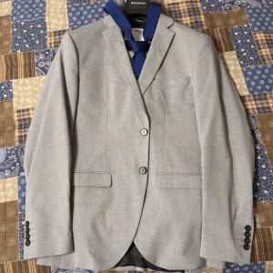 Grå kostymset  - Grå kostymset (Selected Homme) samt kostymväska och slips ingår. Nästan Oanvänt. Kavajen storlek S, Byxorna storlek 48.